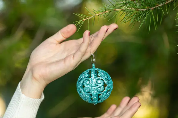 Noel sokaklara dökülür, hediyeler, alışveriş çantaları ve Noel süsleriyle genç bir kadın.