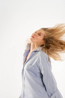 Açık mavi gömlekli ve çizgili kravatlı bir kadın seksi poz veriyor.