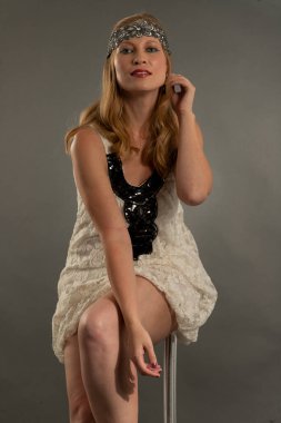 Bella mujer posando con ropa estilo anos veinte, diadema, estilo de vida antiguo y vintage