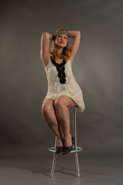 Bella mujer posando con ropa estilo anos veinte, diadema, estilo de vida antiguo y vintage