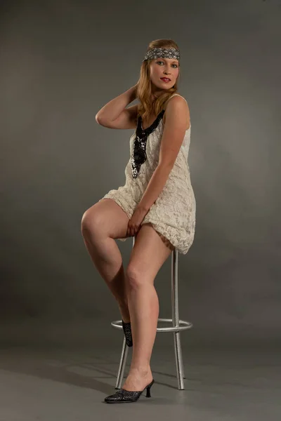 Bella mujer posando con ropa estilo anos veinte, diadema, estilo de vida antiguo y vintage