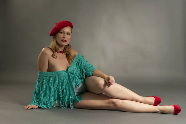Mujer joven posando vestida con estilo frances, con accesorios y zapatos rojos