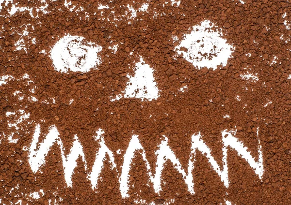 Drawing - a terrible, scary, toothy face for Halloween - on a white background filled with instant coffee.