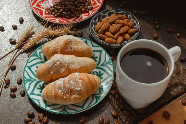 Ekmekli kahvaltı, ahşap masada kahve, kahve çekirdekleri ve bademlerle 45 derece sıcaklıkta kahvaltı.