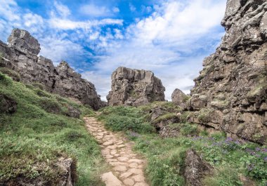 Mavi bulutlu gökyüzü altında Kanyon Almannagja içinde Avrasya ve Kuzey Amerika tektonik plakalar arasında Rift vadisinin içinde yol (Thingvellir Ulusal Parkı, Izlanda) 