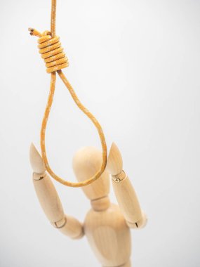 Minyatür ahşap bebek Noose ile halat asılı el çeker. Gallow Noose arkasında bulanıklık rakam. Seçilen odak, yakın görünüm.