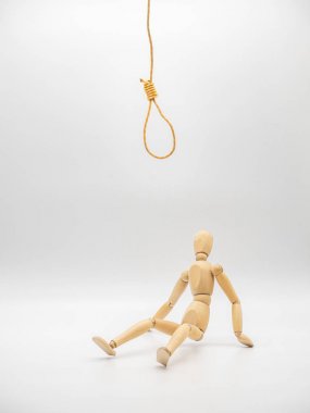 Minyatür ahşap bebek asılı halat ve dokunmatik Gallow ilmik beyaz üzerinde izole altında oturur. Kriz düşünme kavramı.