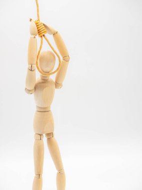 Minyatür ahşap bebek beyaz üzerinde izole Gallows ilmik kafa koyuyor. Asılı halat ile intihar konsepti.