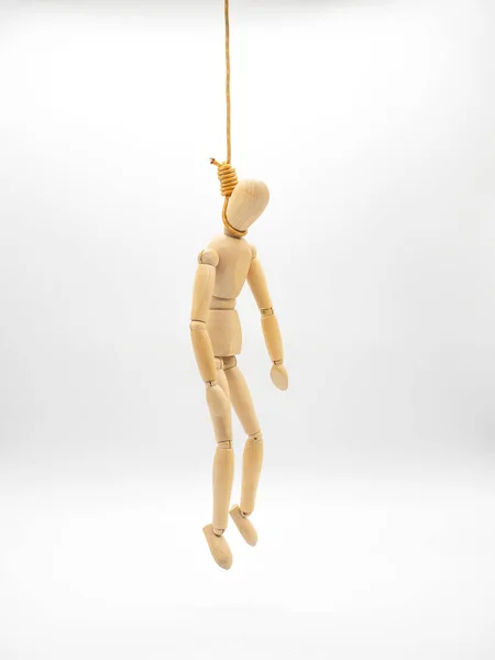 Hanged miniature wooden doll with head in the noose of gallows isolated on white.