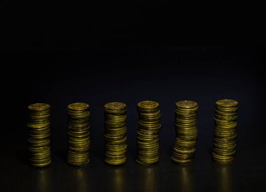 Siyah arka planda izole altın sikke yığını. Eşit yükseklikte altın sikke yığınları. Dikey çubuk grafik.