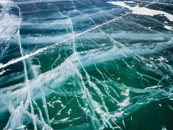 Network of cracks in thick solid layer of ice of a frozen surface Baikal lake in Siberia (Russia)