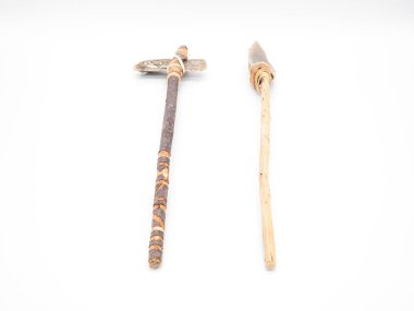 Replicas of the primal stone tools with wooden handles and leather strapping isolated on white background. Primitive stone axe and dagger or spear: weapons of the prehistoric peoples. Perspective view clipart
