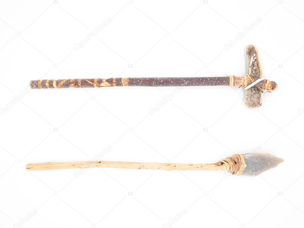 Replicas of the primal stone tools with wooden handles and leather strapping isolated on white background. Primitive stone axe and dagger or spear: weapons of the prehistoric peoples.
