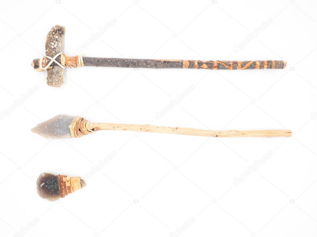 Replicas of the primal stone tools with wooden handles and leather strapping isolated on white background. Primitive stone axe, dagger and hammer: weapons of the prehistoric peoples.