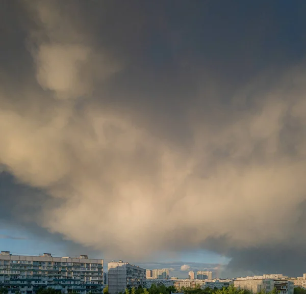 Sky with clouds over apartment buildings of the urban district. Panorama of the morning cityscape. Moscow city, Russia.
