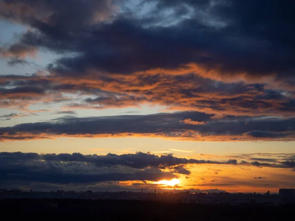 Colorful cloudy epic sky on sunset over the panoramic dark silhouette of the Moscow city skyline