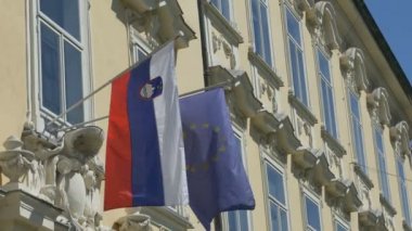 Slovenya ve Avrupa Birliği bayraklarının binaya bakışı.
