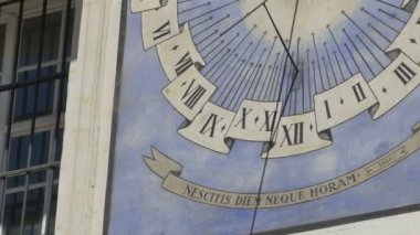 Bir binanın th cephesinde bir güneş saati saati. Güneş saati, güneş ışığının gökyüzündeki görünür konumuna göre gün ışığının ne zaman olduğunu söyleyen bir cihazdır..