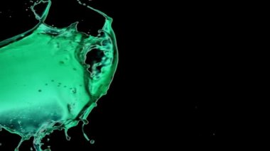 Neon yeşil sıvı siyah arka planda atılıyor - yavaş çekim