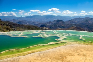 Hierve el agua 'nın güzel manzarası, kaya oluşumları, yeşil su, dağlar ve mavi gökyüzü, Oaxaca, Meksika' da turistik cazibe