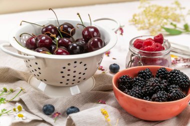 Yaban mersini, ahududu, kiraz ve böğürtlen kaselerin içinde.