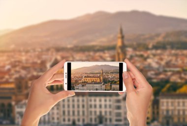 Bir turist Basilica di Santa Croce (kutsal haç bazilika) ile batan güneşin bir cep telefonu tarafından aydınlatılmış batımında Floransa panorama fotoğraf alıyor