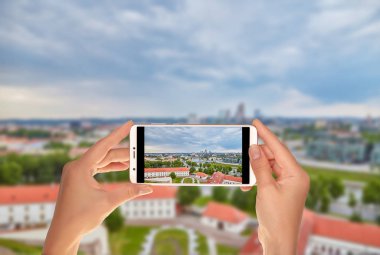 Bir turist Litvanya - Vilnius bir cep telefonuna başkenti hava panoramik bir fotoğraf çekici