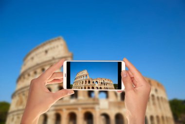 Bir turist Colosseum bir fotoğraf bir cep telefonu üzerinde Roma, İtalya Gökyüzü mavi çekici