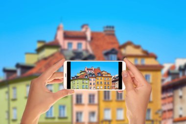 Bir turist merkezi Milano evlerin pencere bir fotoğraf çekici kapattılar ve çiçekler bir cep telefonu ile dekore edilmiş