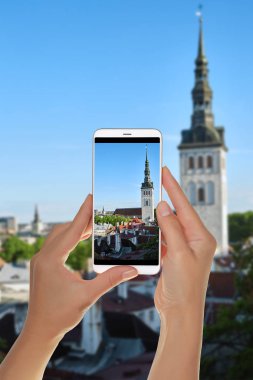 Bir turist eski şehir, Tallinn yukarıdan bir cep telefonu fotoğraf çekme