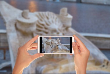 Bir turist bir fotoğrafta ayrıntı Piazza Spagna yakınındaki Roma'daki İspanyol Merdivenleri Çeşme üstünde hareket eden telefon