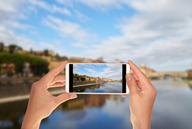 Bir turist Arno Nehri ve Ponte Vecchio Köprüsü Floransa, İtalya iskele bir cep telefonuna bir fotoğraf çekici