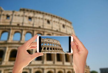 Bir turist bir cep telefonu mavi gökyüzü Roma, İtalya, Coliseum bir fotoğraf çekici