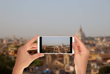 Bir turist Roma manzarası gündoğumu berrak mavi gökyüzünün bir cep telefonu ile fotoğraf çekme