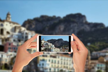 Bir turist bir fotoğraf Amalfi resort kasaba açık yaz güneşli bir günde bir cep telefonu atıyor
