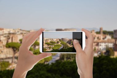 Bir adam bir cep telefonu yaz günü Roma manzarası Colosseum mavi gökyüzü ile bir fotoğraf yapıyor