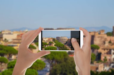 Bir turist Roma cityscape güzel eski Coliseum ile fotoğrafını cep telefonu üzerinde yapıyor