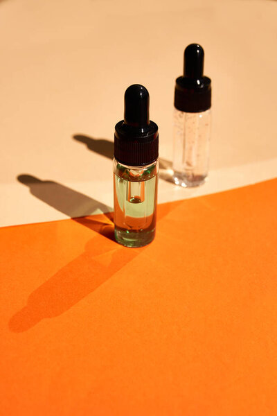 Essential oils on the trendy geometric background with shadows.