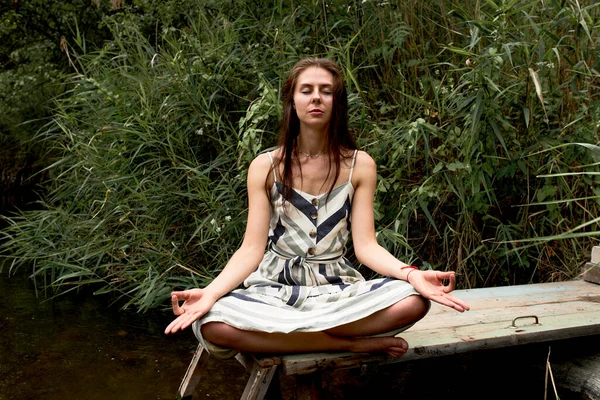Hermosa joven en vestido meditando sobre la naturaleza — Foto de Stock