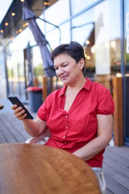 Mutlu olgun kadın cep telefonu kullanıyor.