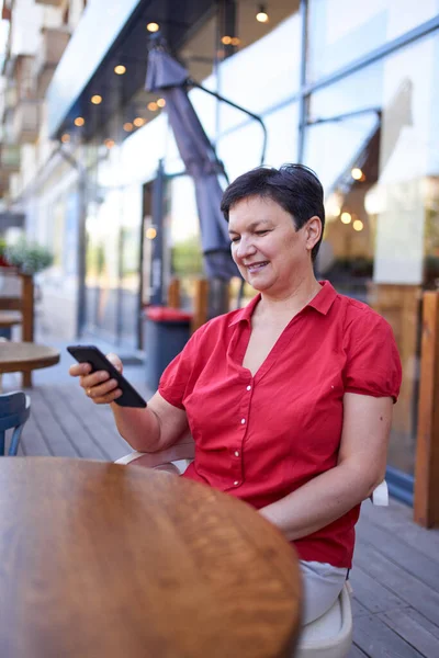 Mutlu olgun kadın cep telefonu kullanıyor.