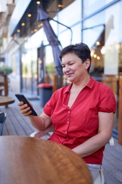 Mutlu olgun kadın cep telefonu kullanıyor.
