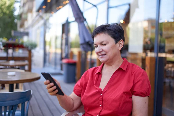 Mutlu olgun kadın cep telefonu kullanıyor.