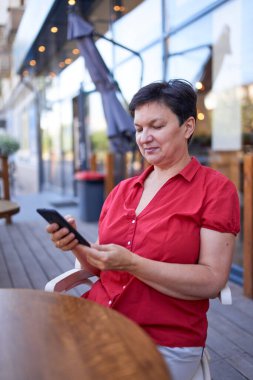 Mutlu olgun kadın cep telefonu kullanıyor.