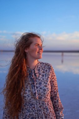 Uçan kızıl saçlı güzel bir genç kadın.