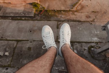 Yürüyüşçünün bacakları yüksek bir binanın kenarından sarkıyor.