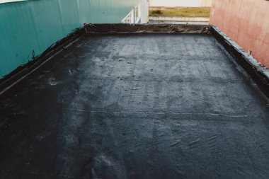Teneke tavan ile birleştirilmiş endüstriyel bir salonun bitumen çatısı.