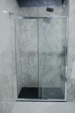 Lüks banyo, küvet, duş rafı ve duşta yürümek. Beyaz mermer ve koyu kahverengi pirinç musluk..