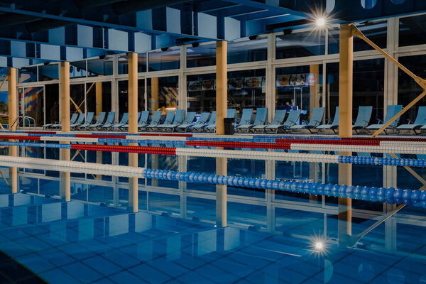 Крытый соревновательный бассейн с дорожками для плавания.