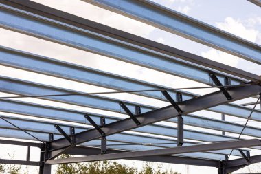 İnşaat halindeki bir çatıyı destekleyen çelik çerçeve yapısı, endüstriyel tasarım ve mimari unsurların sergilenmesi